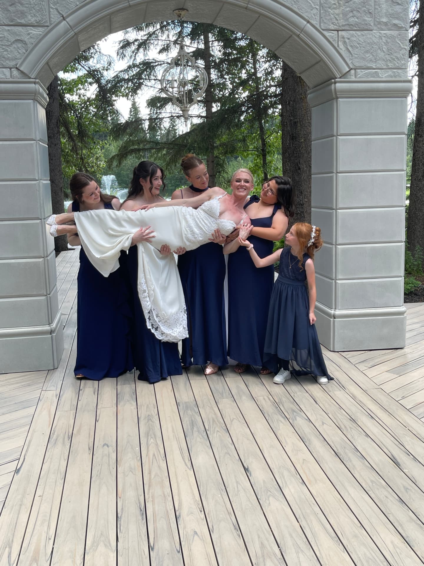 Bridesmaids carrying the bride, captured on a phone